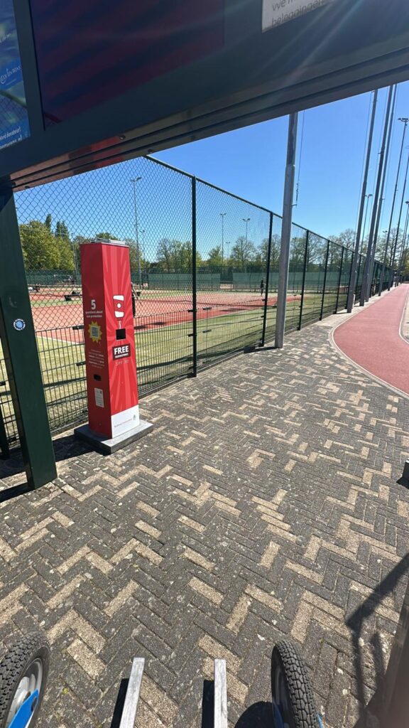 Rote Sonnencreme-Station der Radboud-Universität mit kostenloser Sonnencreme (LSF 30) an den Tennisplätzen des Sportzentrums auf dem Campus in Nimwegen